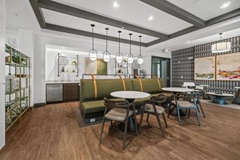 A modern dining area with a wooden floor and a green sofa.